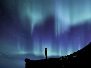 Aurora boreale in Islanda con un uomo nel centro