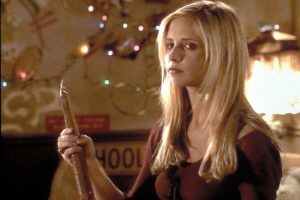 Buffy la protagonista bionda della sua serie con dietro delle lucine e in mano un coltello