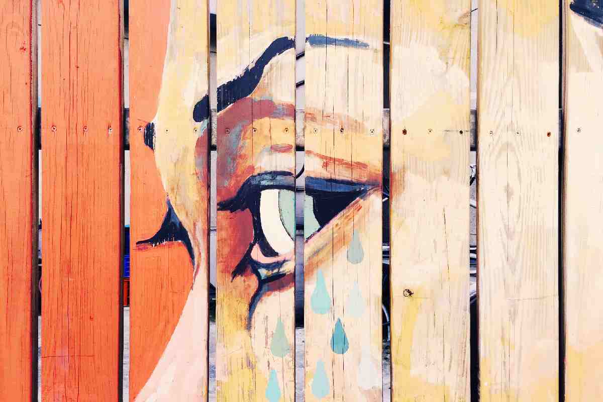 Dipinto di un volto di profilo su ringhiera di legno