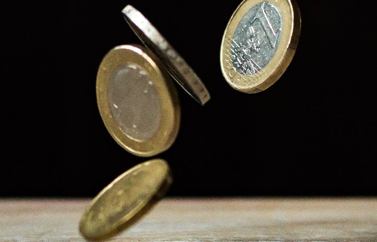 Quattro euro in moneta che cadono
