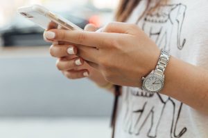 Telefono in mano di una ragazza con lo smalto