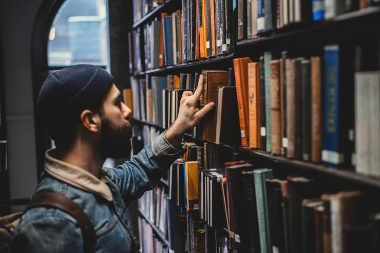 Ragazzo prende un libro in biblioteca